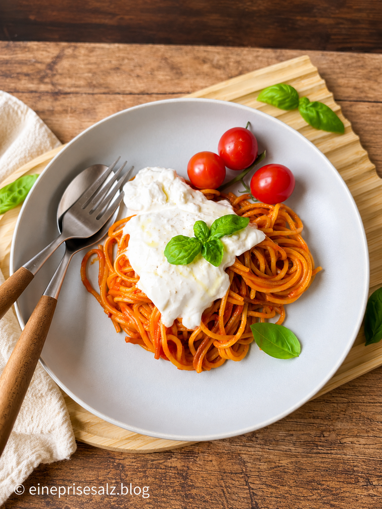 Spaghetti all’Assassina mit Burrata auf einem grauen Teller